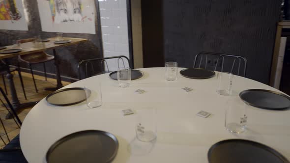 Handheld Pan Around Table with Simple Setting at Empty Restaurant