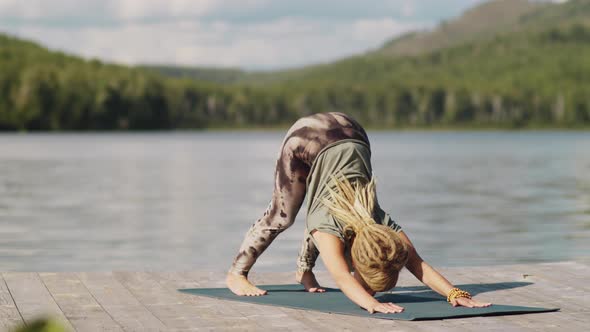Young Woman Practicing Vinyasa Yoga Outdoors