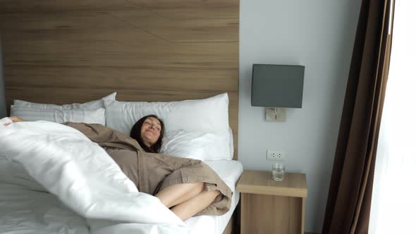 Girl in Bathrobe Awakes and Drinks Clean Water in Hotel Room