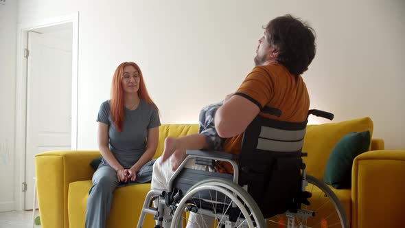 Man in a Wheelchair Playing with His Baby and His Wife Watching Them