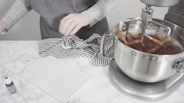 Step by step. Mixing ingredients in a standing kitchen mixer to bake red velvet cupcakes.