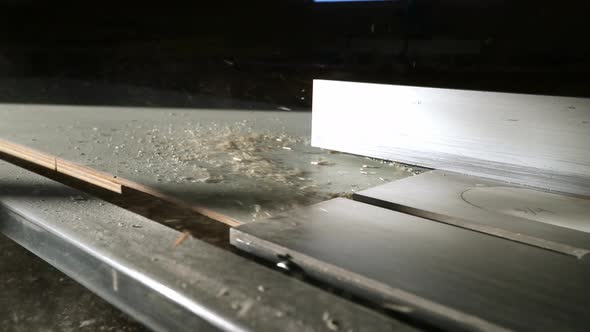 Slow motion sawdust being blow across a table saw surface.