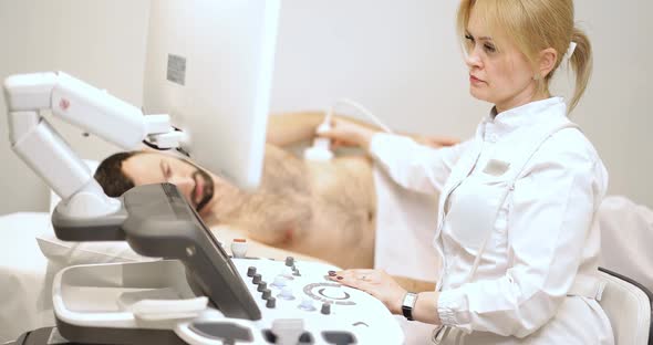 Doctor Examining Males Kedneys with Ultrasound Scan in Clinic