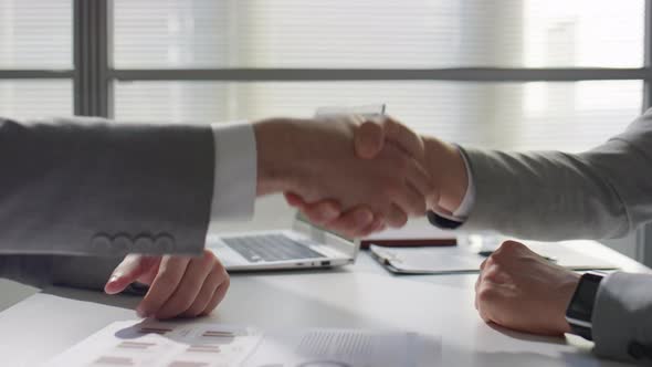 Businessmen Shaking Hands and Having Discussion in Office