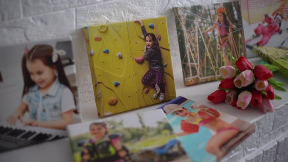 Photo Canvases of Active Little Girl and Flowers Tulips As a Holiday Gift Lie on the Shelf