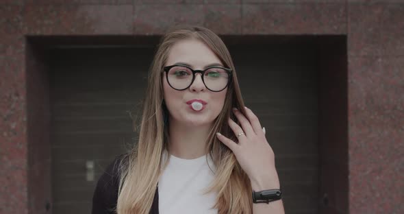 Hipster in Glasses Blows Bubble of Chewing Gum and Has Fun with Bursted It