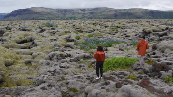 Drone Over Hiking Couple In Mossy Landscape