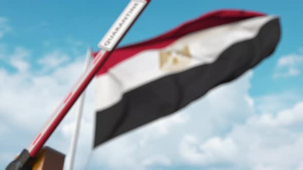 Closing Boom Barrier with QUARANTINE Sign Near the Egyptian Flag alt