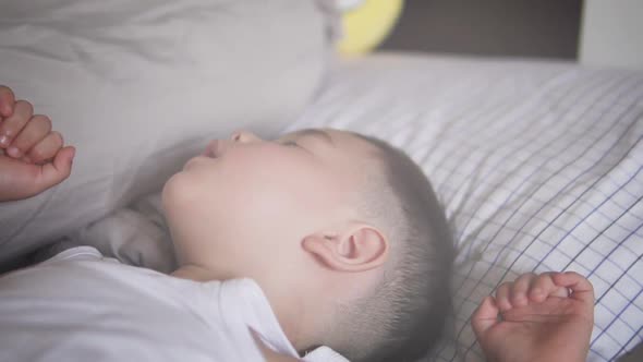 Close up truck or slide right and left of a sweet two years old Asian kid wearing fresh clothes in d