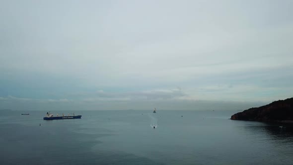 Lowering Shot of Ocean with Ships in Background