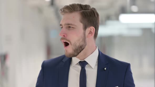 Sleepy Young Businessman Yawning