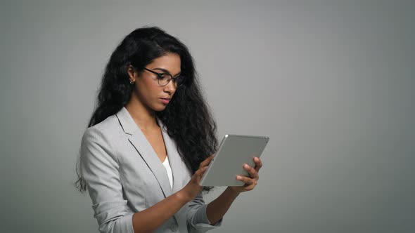 Young African businesswoman uses a digital tablet in studio shot.  
