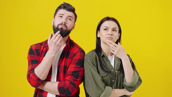 Multiracial Couple Pointing Fingers Up Having Great Idea Posing Over Yellow Studio Background