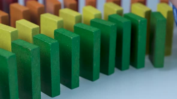 Line up of Dominoes in Rainbow Falling Colors with LGBT Colors of a Hand