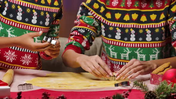 African American Mom and Little Daughter in Bright Holiday Sweaters Cut Festive Homemade Cookies