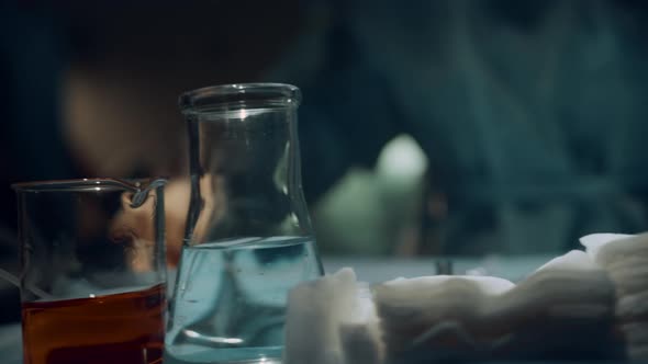 Nurse Preparing Sterile Instruments on Table in Dark Emergency Room Closeup