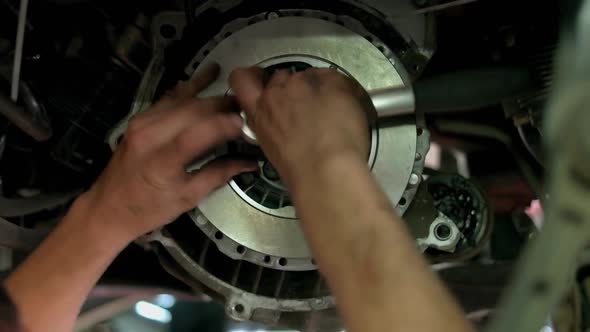 Close Up Screwing Bolts on a Car Clutch Disk