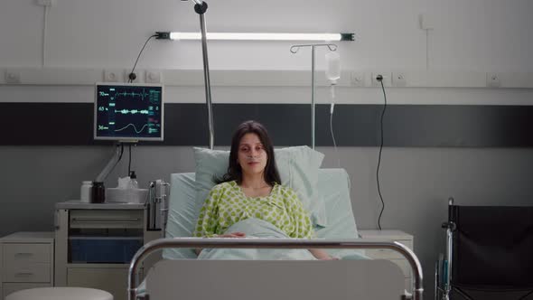 Patient Wearing with Nasal Oxygen Tube Looking Into Camera Sitting in Bed