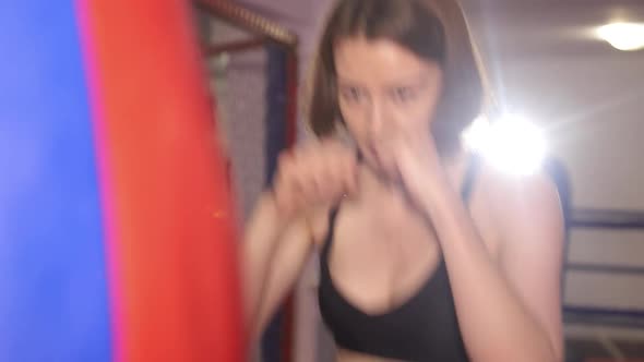 Girl boxer practices punches. Professional women's boxing.