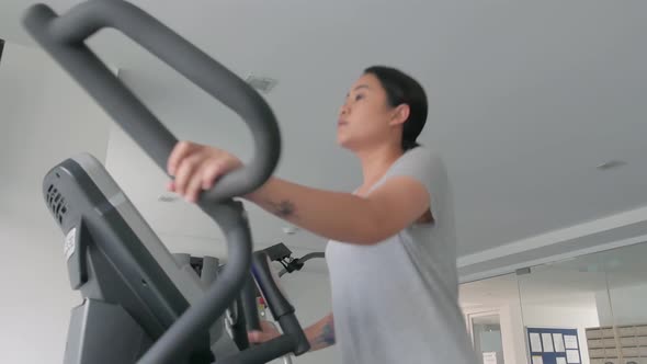 Asian Woman FitnessAsian Woman working out on Various Fitness EquipmentFitness Equipment