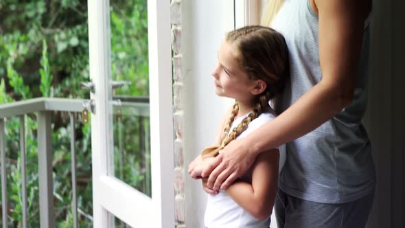 Mother and daughter looking through window in bedroom 4k