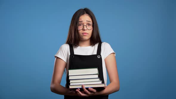 Asian Student Is Dissatisfied with Amount of Homework and Books, Girl with Books, She Is Annoyed