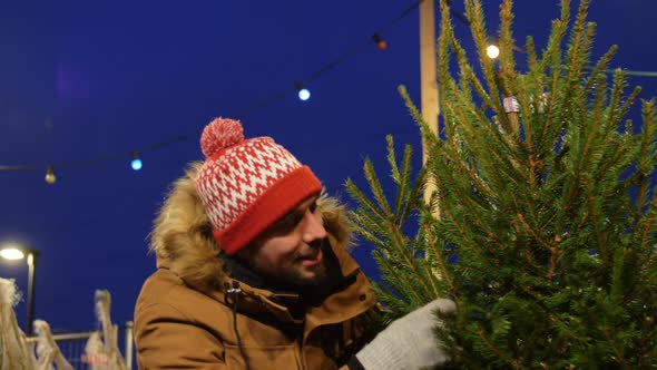 Happy Man Buying Christmas Tree at Market