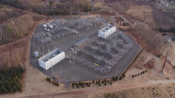 Aerial Drone Shot Orbiting a Large Electrical Substation Next to Farmland
