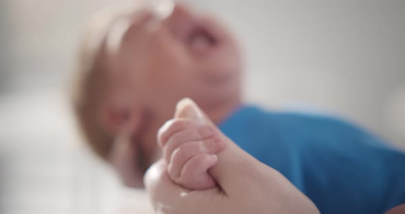 Focus on Baby Boy Tinny Hand Holding Mother Finger