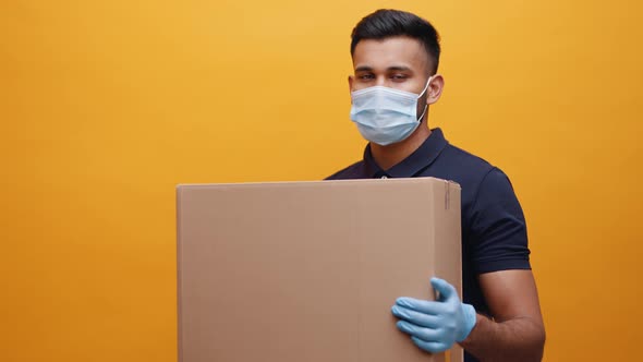 Young Indian Man Holding Big Cardboard Box and Nodding His Head