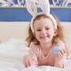 A Little Girl with Brown Hair is Lying on the White Bed - VideoHive Item for Sale