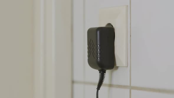 Man plugging and unplugging a wall charger. Close up