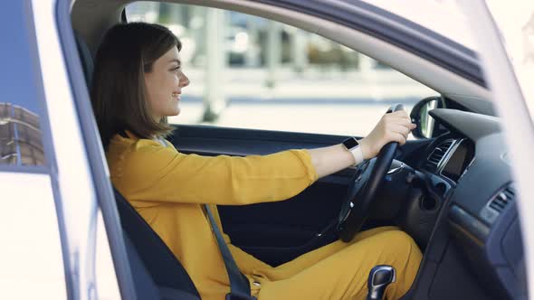 Woman Fastens Car Seat Belt With Hand in the Electric Vehicles