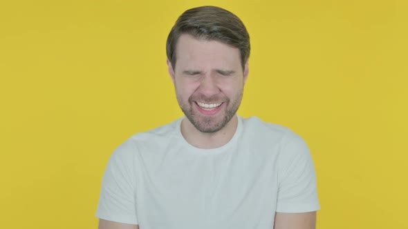 Laughing Young Man on Yellow Background