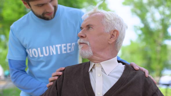 Male Volunteer Smiling to Senior Pensioner