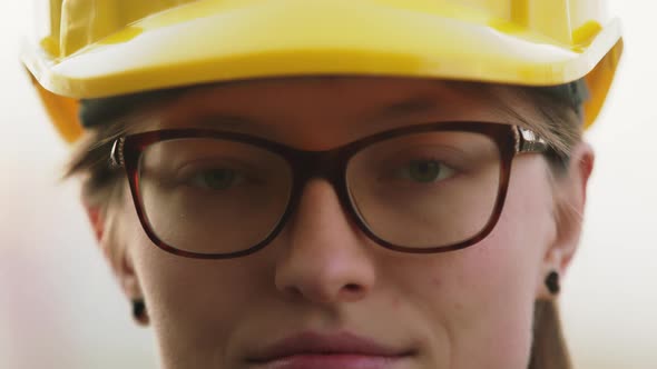 Close Up. Young Woman, Engineer with Yellow Hard Hat . Portrait, Slow Motion with Shallow Depth of