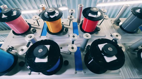Many Colorful Spools Spinning at a Factory