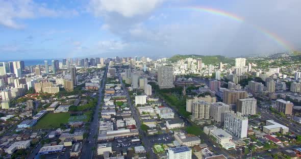 Aerial shot sitting high above the city of Honolulu with a rainbow in the sky