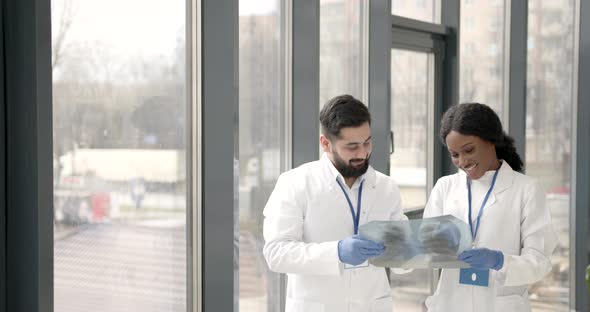 Doctor and Coworker Standing and Looking at Xrays in Clinic