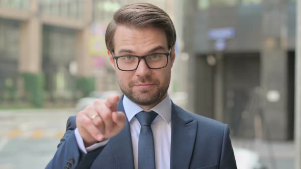 Portrait of Businessman Pointing at the Camera and Inviting