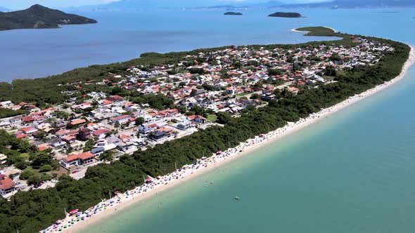 Aerial drone view of urbanized tropical beach on peninsula with many summer houses facing the sea