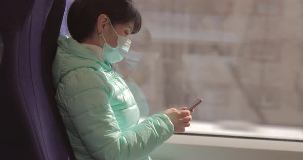 Woman Wearing a Protective Medical Face Mask Rides on a Train During the Covid 19 Quarantine