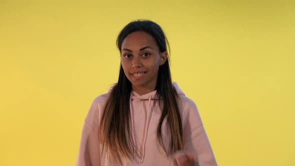 Beautiful Mixedrace Woman Making a Hush Gesture on Yellow Background