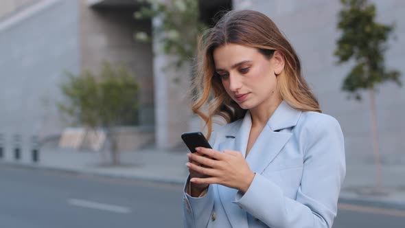Serious Caucasian Young Elegant Business Woman Using Social Media Application on Smartphone Texting