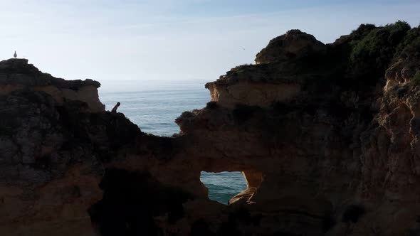 Silhouette Against the Sun a Young Guy on a Mountain Cliff is About to Make an Extreme Jump Into the