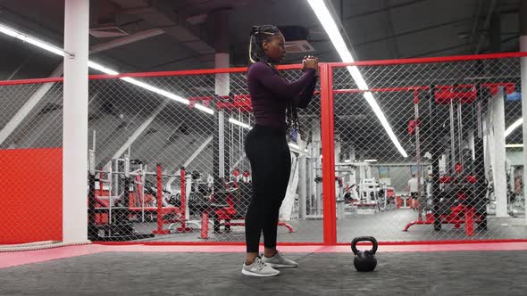 Sports in the Modern Gym  Africanamerican Woman Squatting