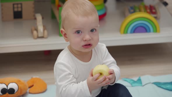 Kid Eats an Apple Sitting on the Floor and Watching Tv