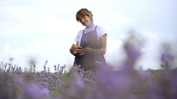 Cheerful Slim Woman Making Bouquet of Lavender Flowers Smelling Fragrance and Smiling