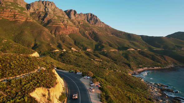 Scenic coastal drive along Chapmans Peak road in Cape Town at sunset, aerial