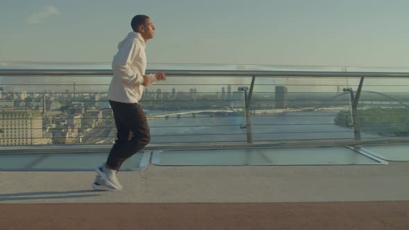 Motivated Sporty Fit Handsome African Male Jogger Running in City at Sunrise